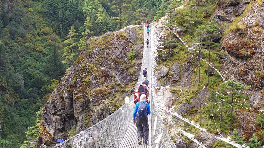Hikers crossing a suspension bridge