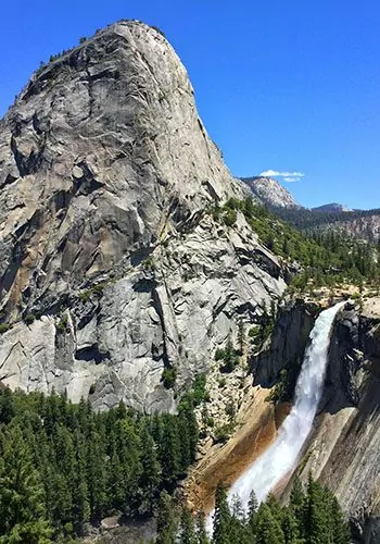 waterfall and grey rock mountains