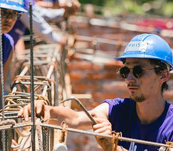 Young people wearing construction hats building