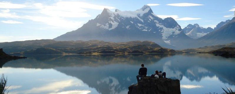 Hikers on a cliff looking at a mountain