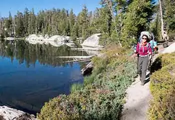 A hiker makes her way around a lake loop trail in Yosemite National Park