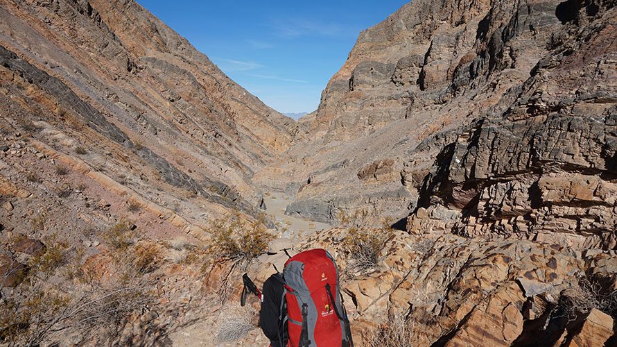Hiker with red backpack in rugged terrain