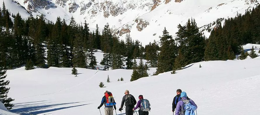 Rocky Mountain snowshoers cross a scenic snowy valley