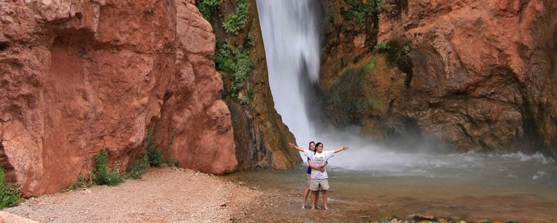Hikers in front of waterfall