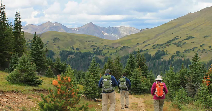 Cloudy days make for cooler hikes as three hikers head into the mountains in Rocky Mountain National Park