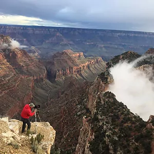 Meta photography of a nature camera man capturing the fog rolling off the Grand Canyon Rim