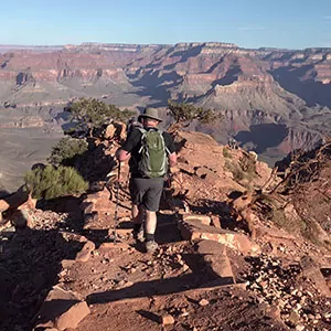 A lone hiker forges on in the sun towards the Grand Canyon rim
