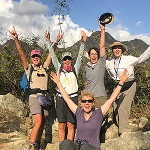 Elated hikers pose at their summit on a guided trip in Peru