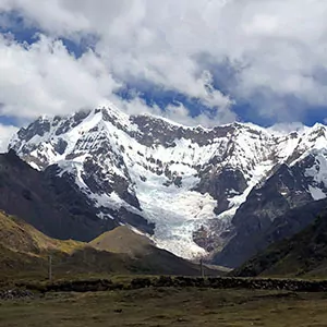 Misty morning mountains of Peru with blue skies and green grass