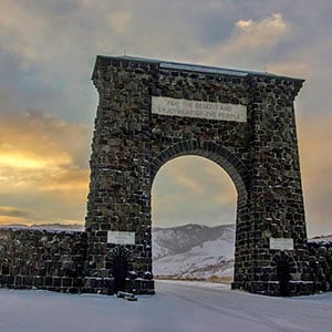 Entrance stone archway to Yellowstone National Park during sunset