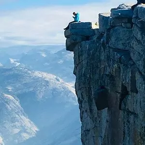 A hiker sits atop a popular outlook in Yosemite National Park