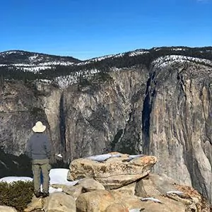 A hiker looks out from their summit view in yosemite national park