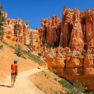 A hiker enjoying the serenity of being alone on a trail with hoodoos all around.