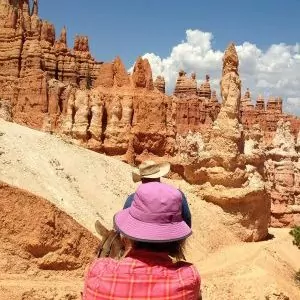 Two hikers explore the hoodoo rock formations in the desert.