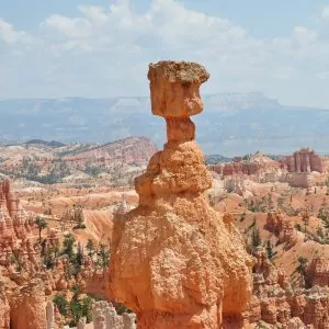 Desert tower searing above the skyline of blue skies spotted by puffy clouds