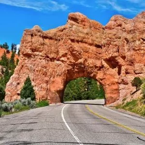 A sandstone archway with a road running through it.