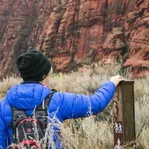 Hiker touches a trail marker during a February hike in Bryce Canyon