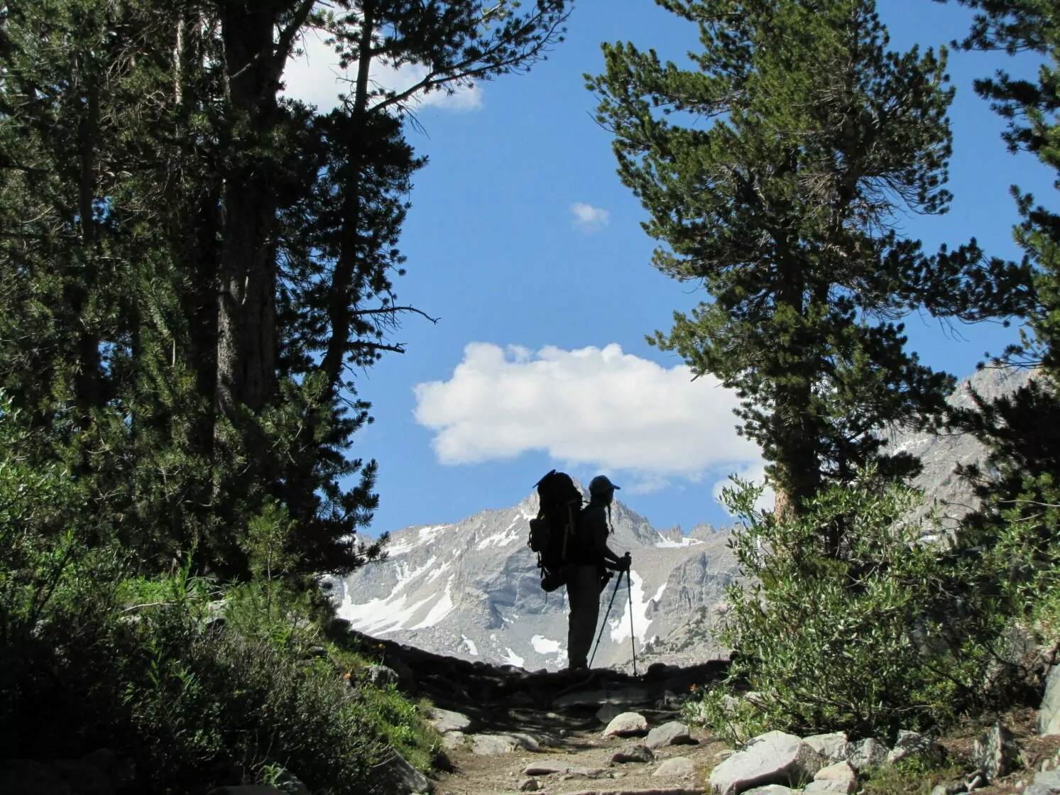 best beginner backpacking trips, little lakes valley, hiker, backpacking, framed trees, clouds, best trips