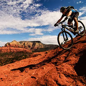 A mountain biker heads downhill on the red rocks of the desert