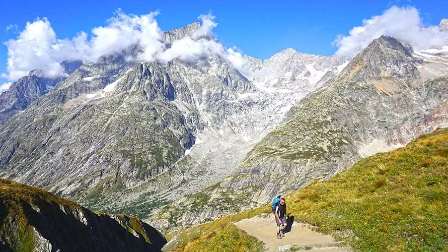 Lone male hiker in front of big views of the Alps