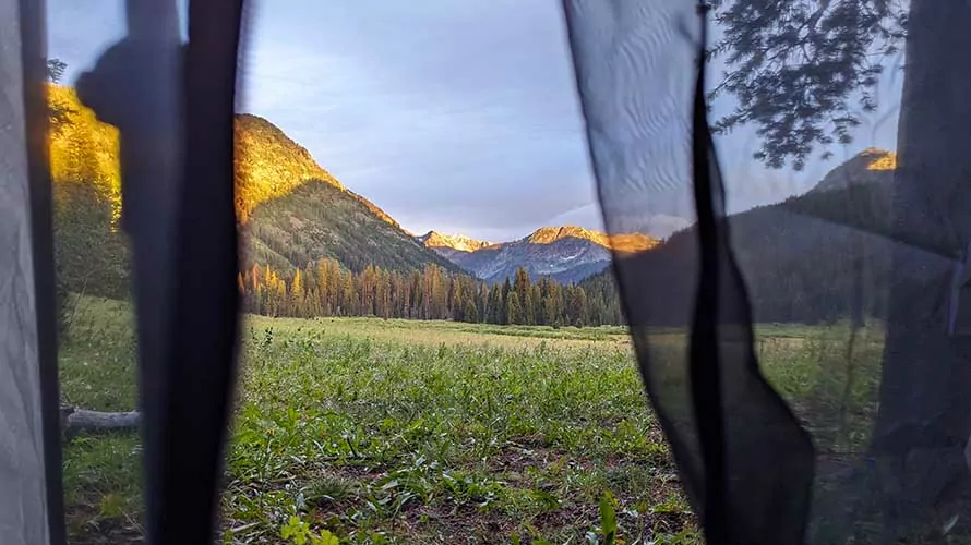 Looking out of a tent at a vast meadow in the Tetons, Wyoming