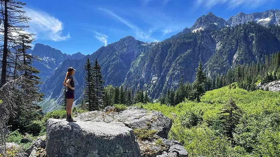 A women backpacker looking up at the mountains of the North Cascades