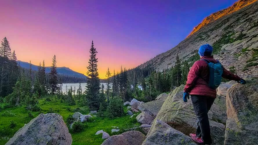 Woman looking out at sunset over Thunder Lake, Rocky Mountain National Park