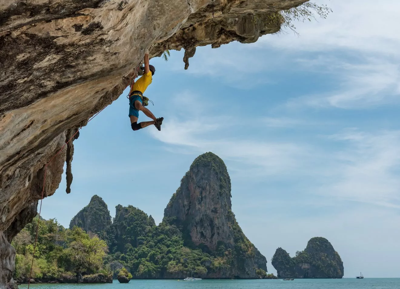 A male climber dangles from a steep sport climb in Railay Beach, Thailand. 