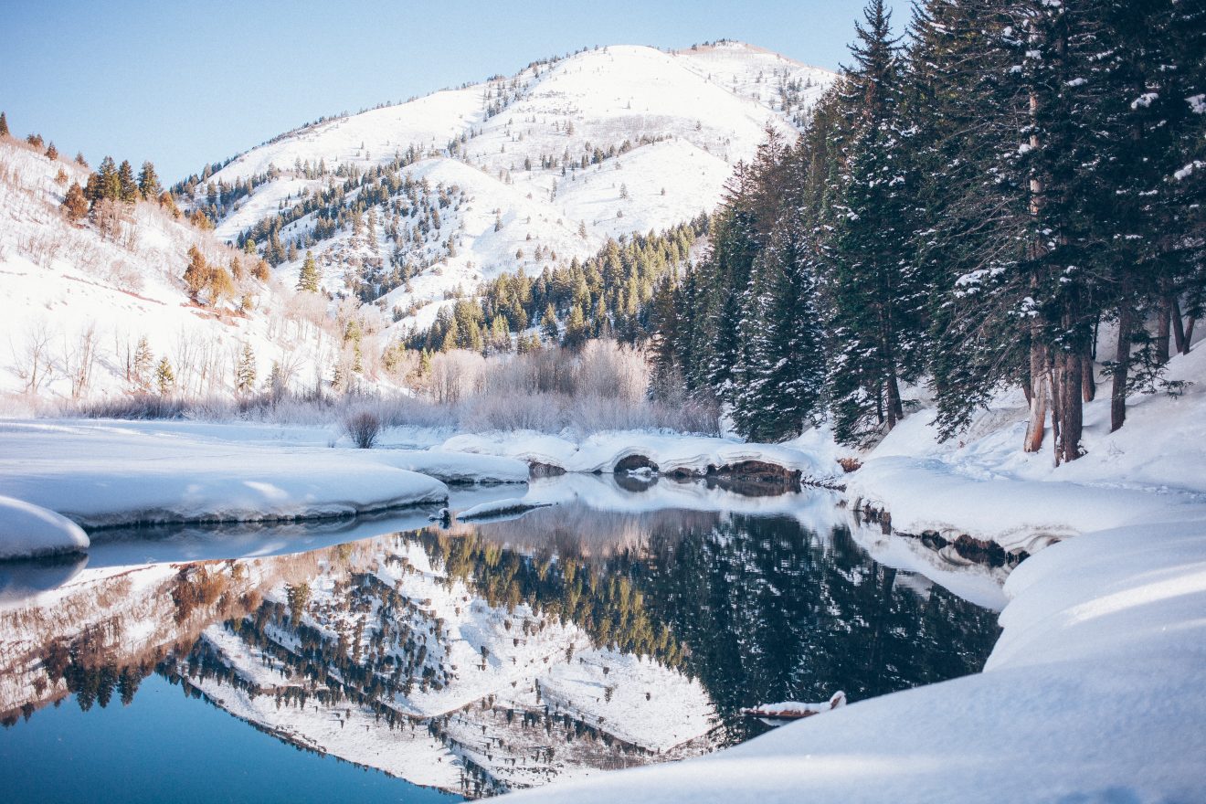 Reflection of a mountain in a clear lake. Snow covers the landscape.