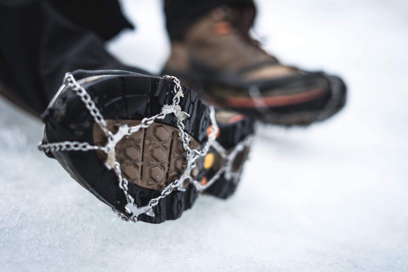 Microspikes on a hiking boot on snow.