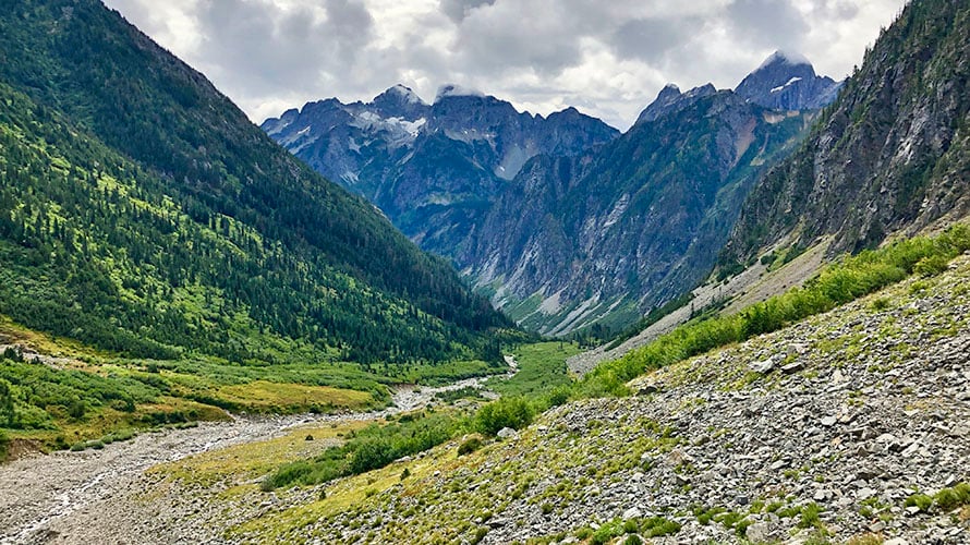 Steep steps on mountain path to the green alpine valley