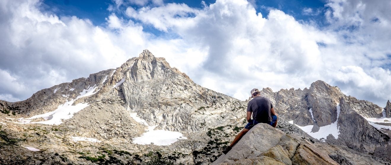 Hiker sitting on a rock in the alpine in Yosemite.
