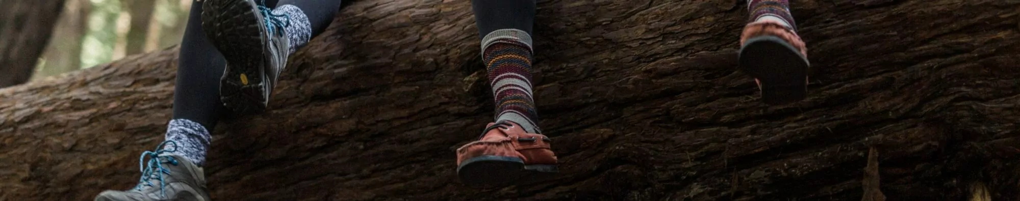Couple sitting on log with hiking socks