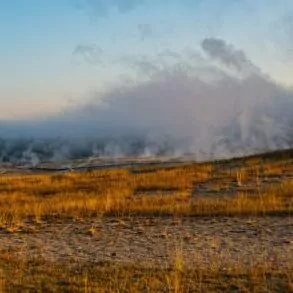 Yellowstone in October, fall autumn orange grass geyser steam sunset