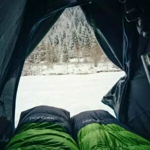 sleeping bag green tent snow winter Yellowstone in January Backpacking