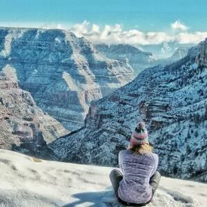 backpacking grand canyon in December winter woman hat sweater snow cliff