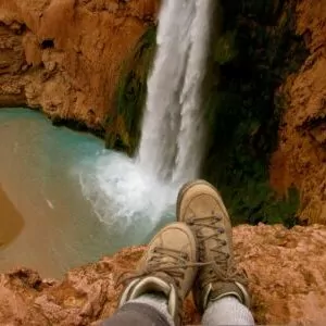boots backpack hiking grand canyon in march waterfall pool cliff overlook