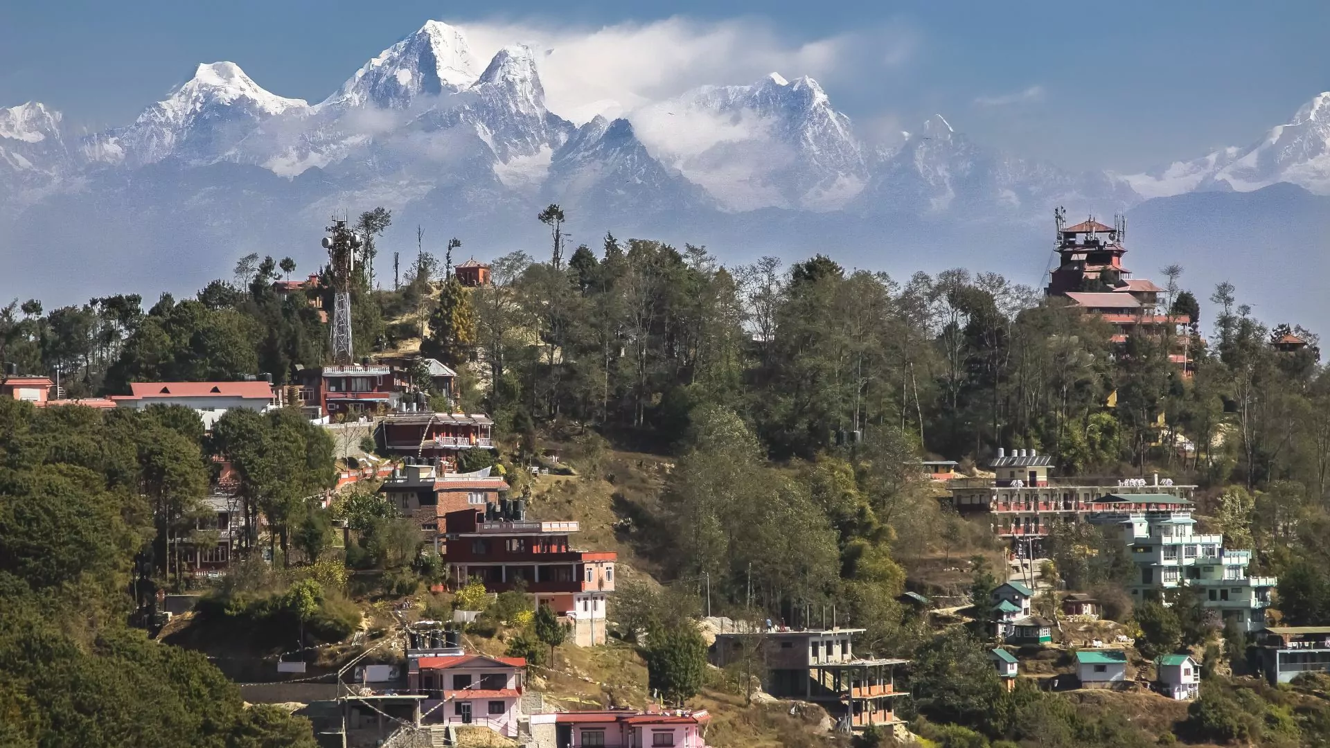 The village of Lantang, Nepal perches in the foreground with windswept peaks behind