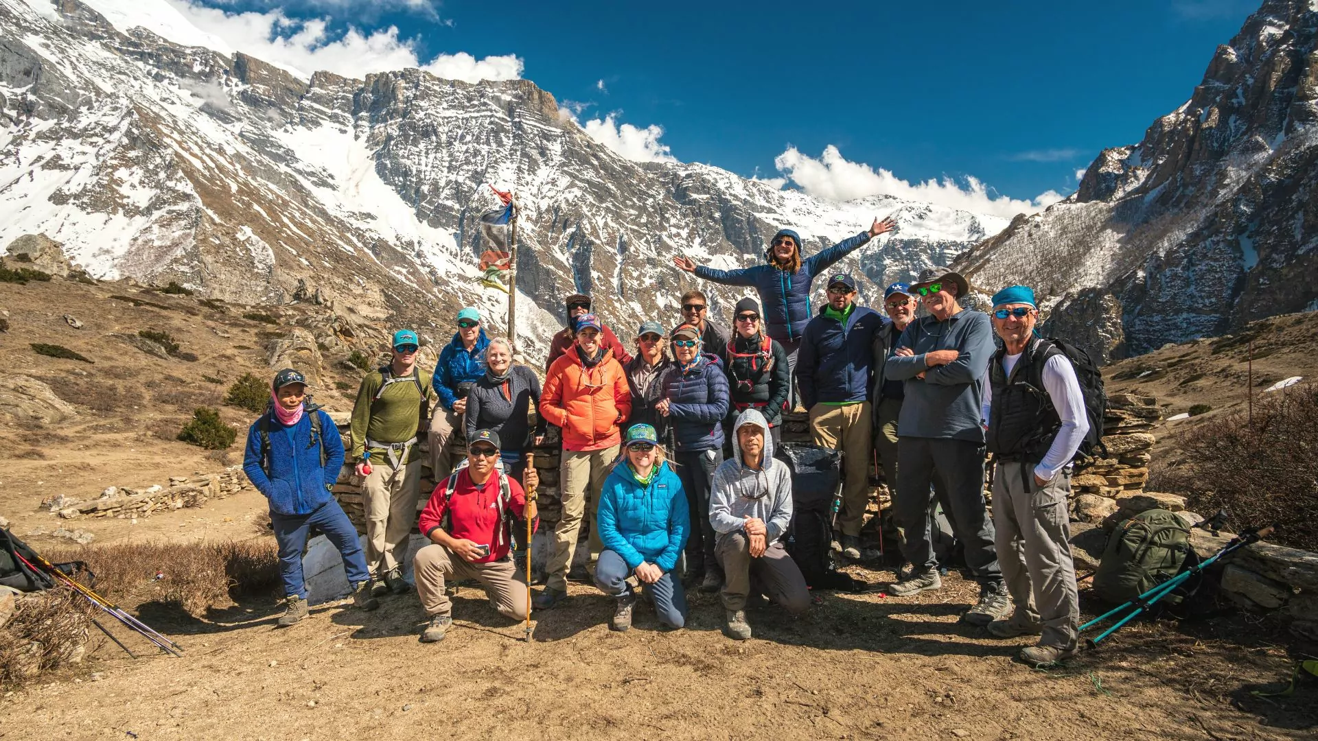 A group of happy hikers pose together in the mountains
