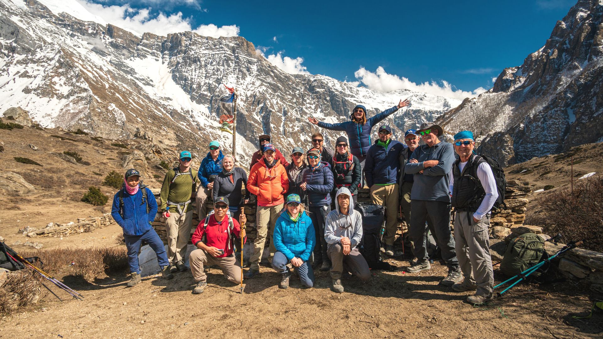 A group of happy hikers pose together in the mountains