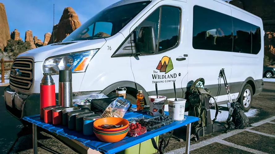 Wildland Trekking van and breakfast spread at a trailhead in Arches National Park