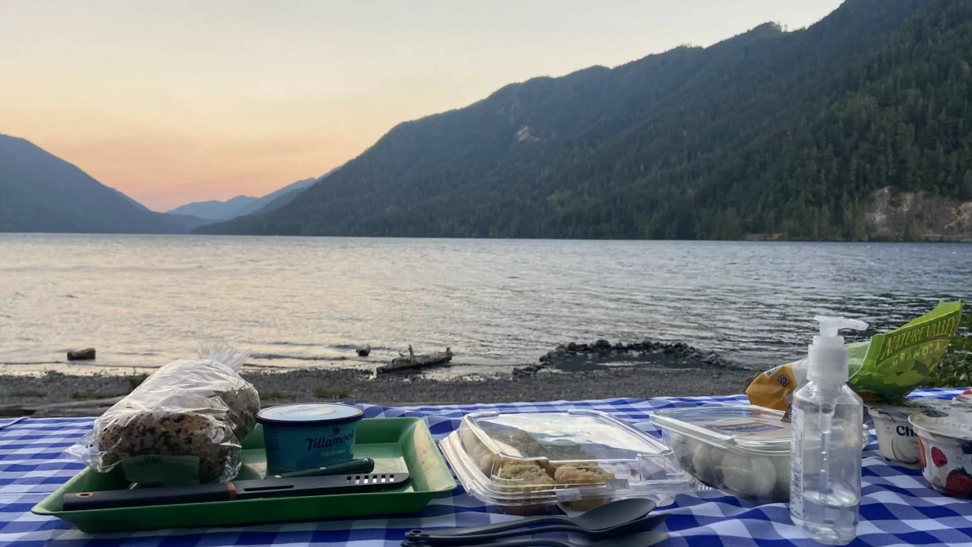 Picnic spread on table beside the shore at dawn