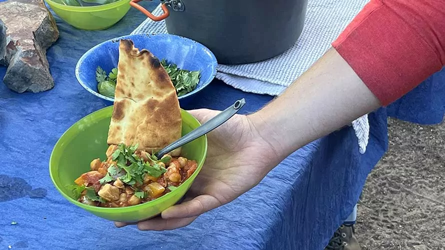 Guide holding a bowl of food on a Wildland Trekking backpacking trip