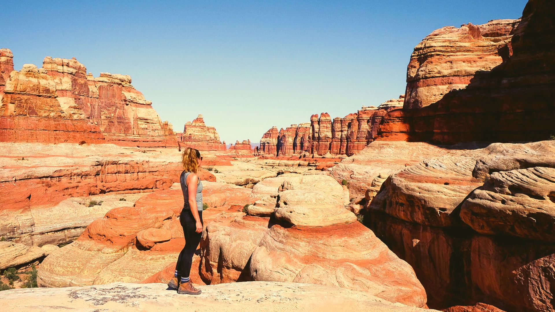 Woman stands alone looking out over canyonlands national needles district