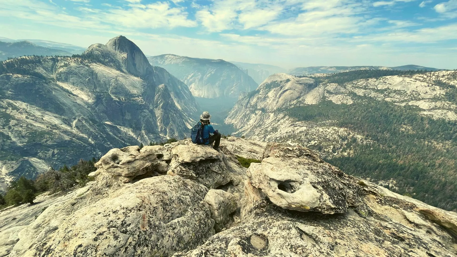Yosemite national park solo traveler perches on granite dome