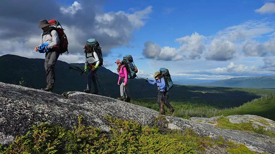Backpackers hiking up rocky ridge on Kesugi Ridge Trail