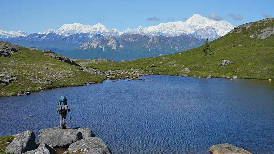 Backpacker standing by lake on Kesugi Ridge, Alaska