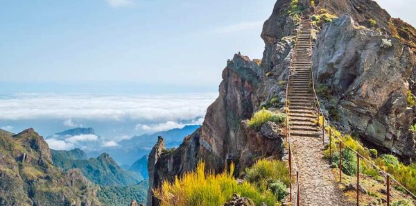 "Stairs to heaven" - Breathtaking view at famous mountain footpath from Pico do Arieiro to Pico Ruivo on the Portuguese Madeira island. Trekking Around the world traveling with kids concept image.