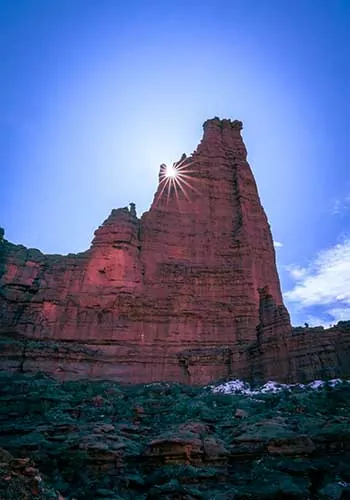 Sun peeking out from behind the Fisher Towers in Utah