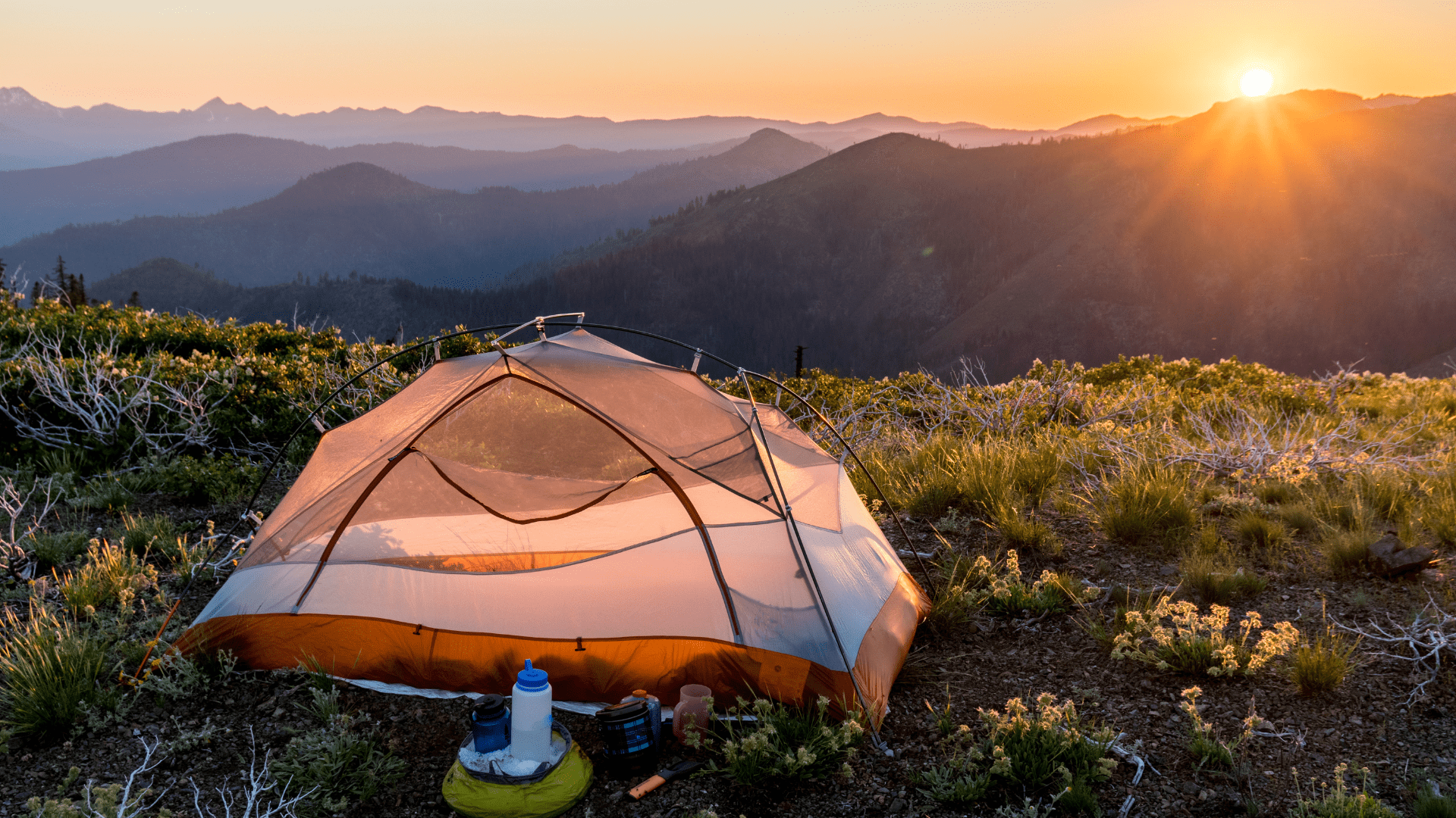 Backpacking tent in front of mountain sunrise